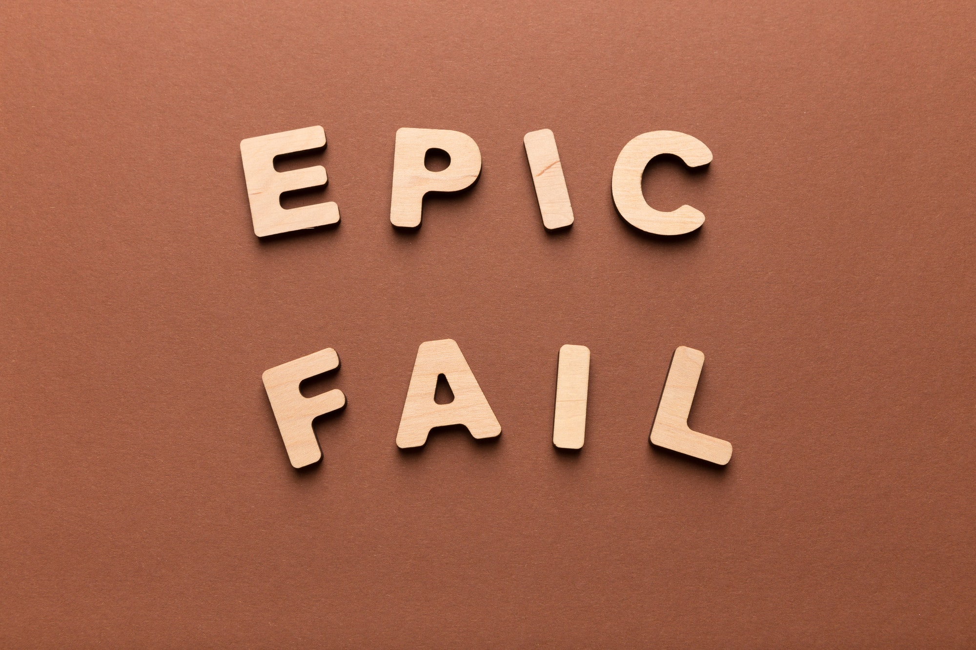 Wooden letters spelling Epic fail on brown background